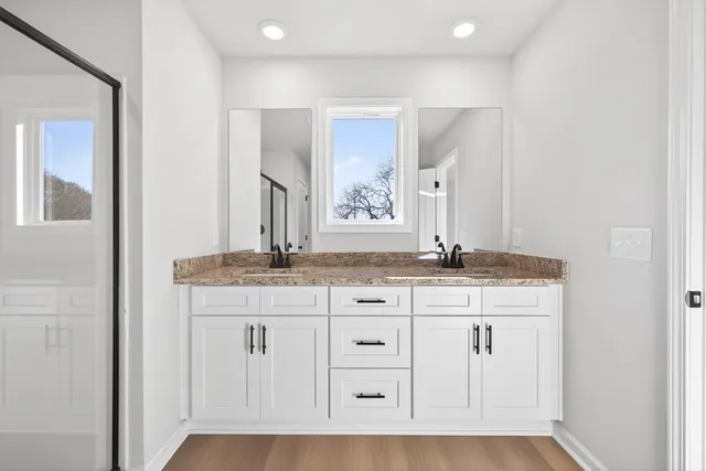 a bathroom with a granite countertop sink and a mirror