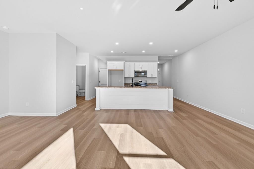 578 Madison Street, Unit 100 Commerce, GA 30529 - Photo 5 of 37 a view of a kitchen with wooden floor and electronic appliances