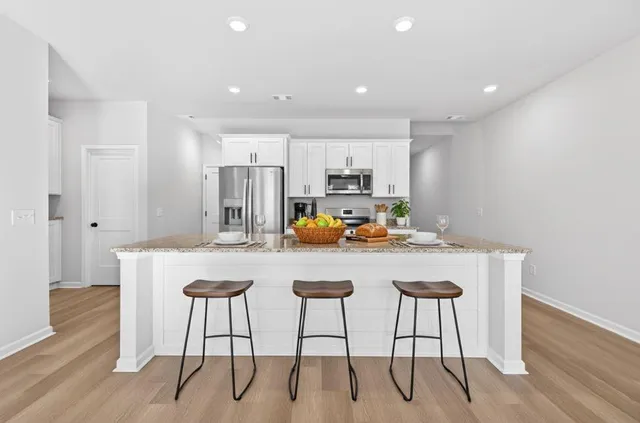 a kitchen with stainless steel appliances granite countertop a dining table chairs and granite counter tops