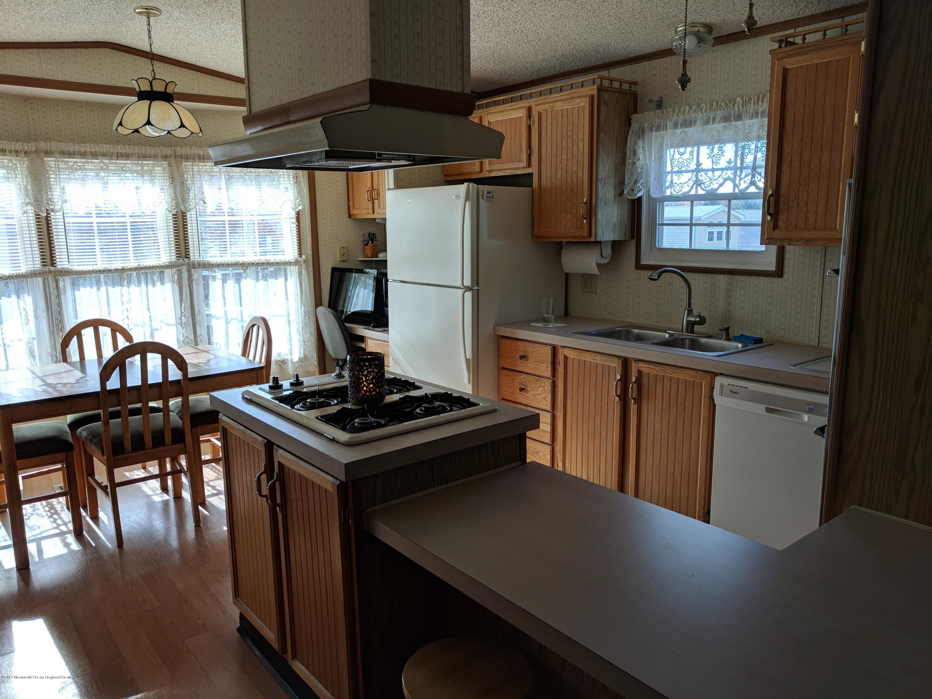 42 Ruffian Way Howell, NJ 07731 - Photo 4 of 7 a kitchen with granite countertop a stove a sink and a refrigerator