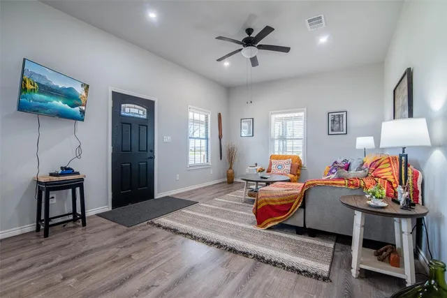 a living room with stainless steel appliances kitchen island a table and chairs