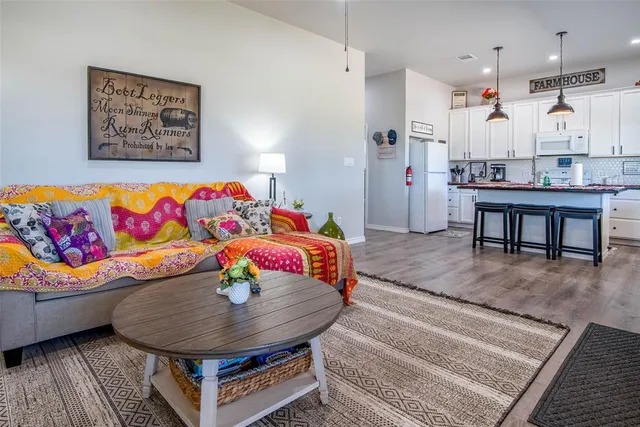 a kitchen with stainless steel appliances granite countertop a stove a sink dishwasher with a dining table and chair with wooden floor