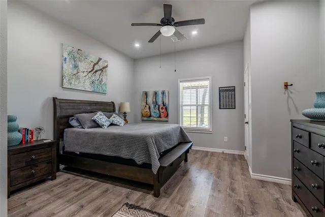 a bedroom with a bed a dresser and painting on the wall