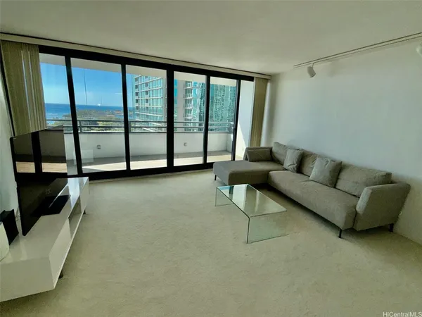 a living room with furniture and a floor to ceiling window