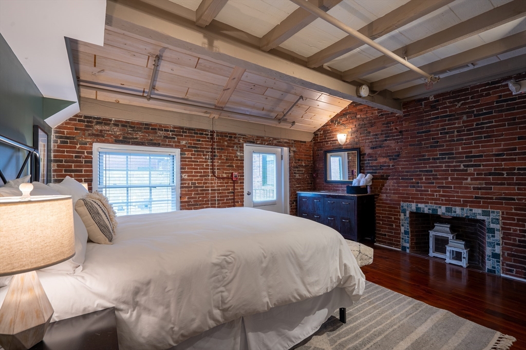 15 Union Street, Unit 3 Boston, MA 02108 - Photo 11 of 17 a large bed sitting in a spacious bedroom next to a fireplace
