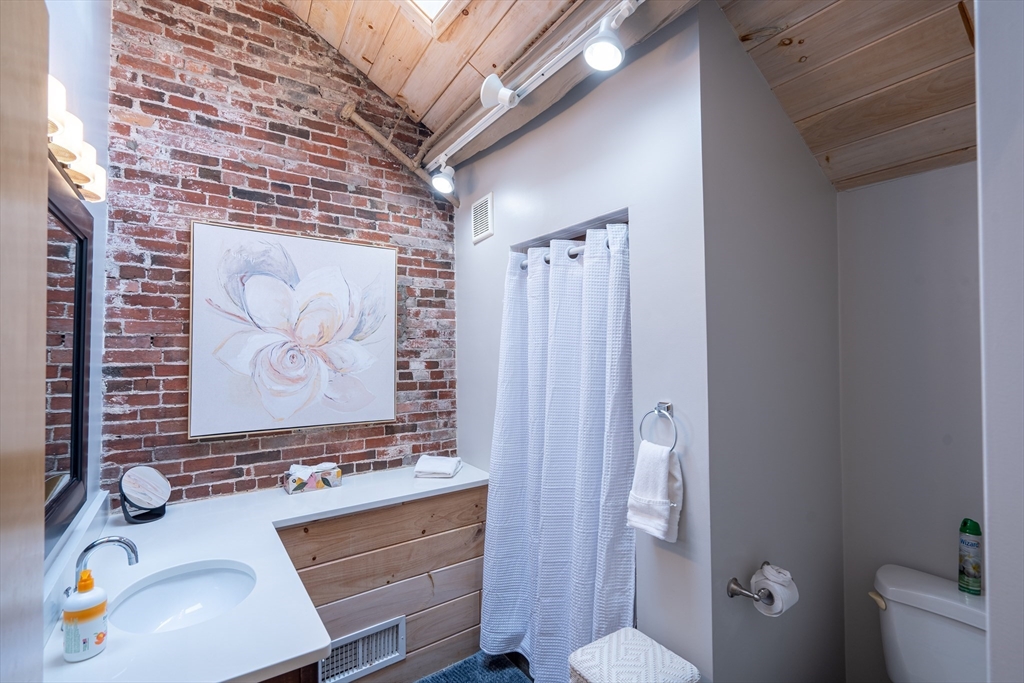 15 Union Street, Unit 3 Boston, MA 02108 - Photo 15 of 17 a bathroom with a sink a toilet and shower curtain