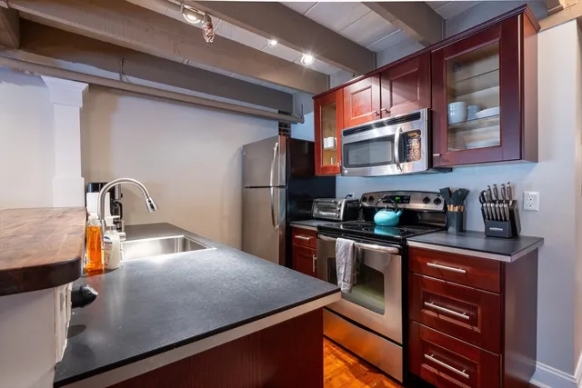 a kitchen with stainless steel appliances granite countertop a sink refrigerator and microwave