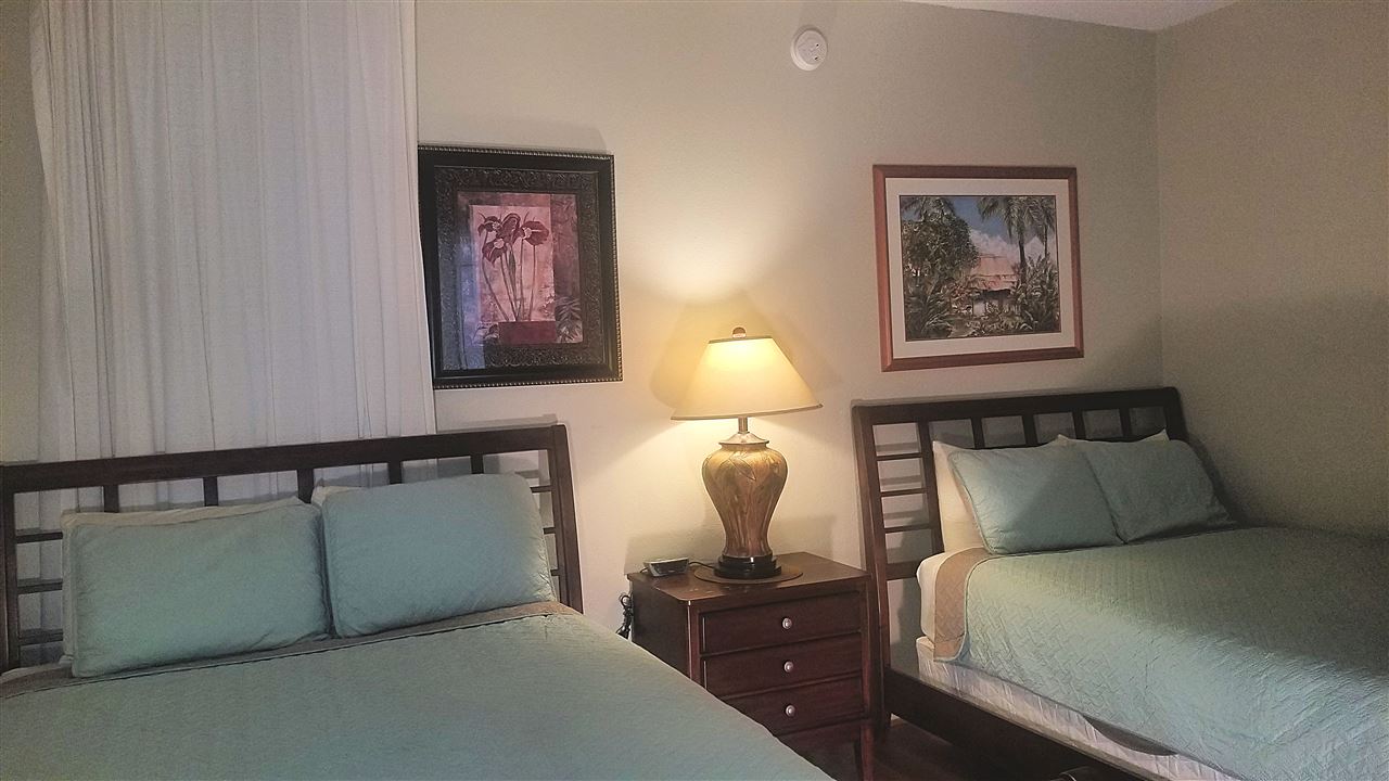 4299 Lower Honoapiilani Road, Unit 134 Lahaina, HI 96761 - Photo 18 of 29 a bedroom with a bed and a lamp on dresser