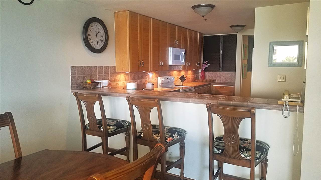 4299 Lower Honoapiilani Road, Unit 134 Lahaina, HI 96761 - Photo 4 of 29 a kitchen with a table chairs and a stove