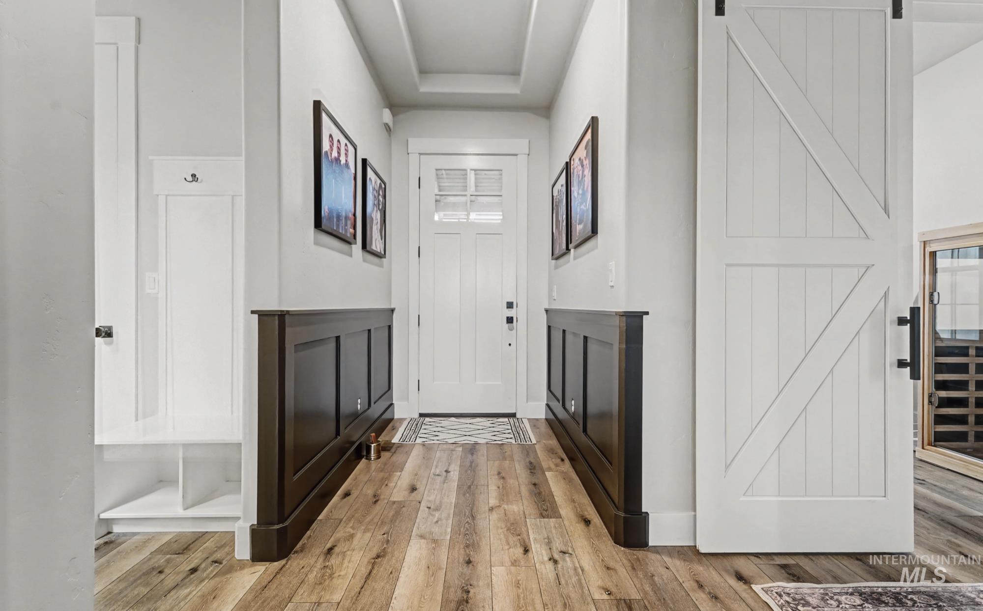 18357 North Burnt Car Way Boise, ID 83714 - Photo 12 of 48 Entryway with a barn door, light wood-type flooring, a sauna, and a tray ceiling
