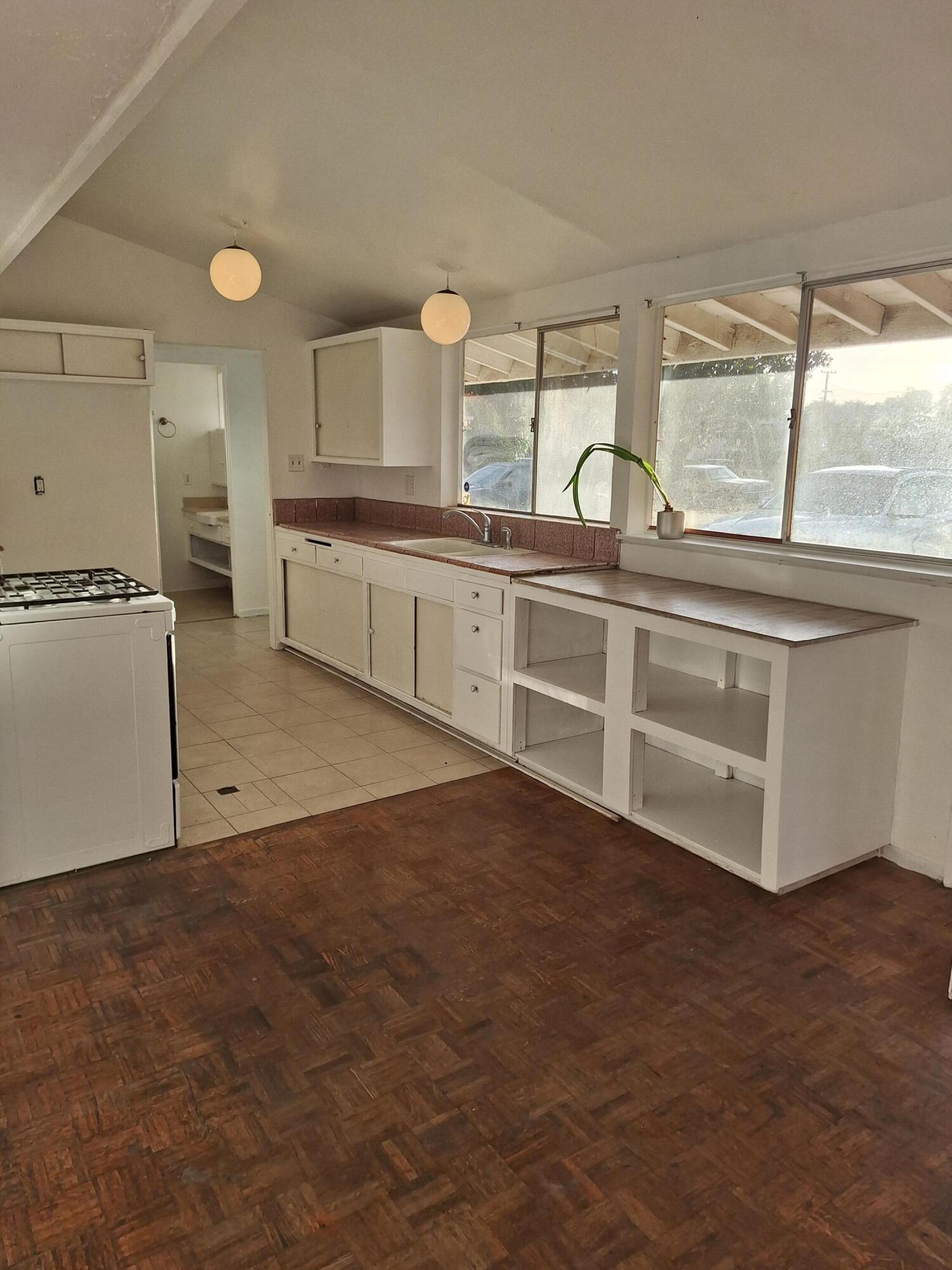 424 North Second Street Lompoc, CA 93436 - Photo 2 of 21 a open kitchen with granite countertop a stove top oven a sink and white cabinets
