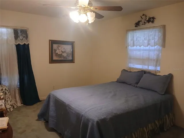 a bedroom with a bed and a flat tv screen on the dresser