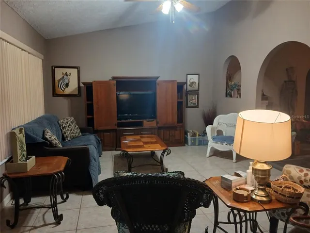 a living room with furniture a rug and a lamp