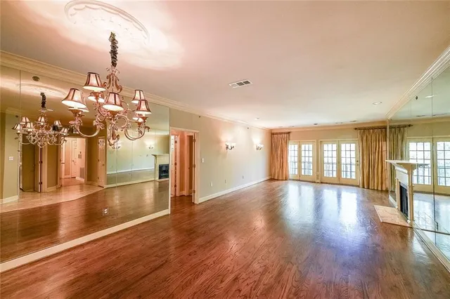 a view of empty room with wooden floor and windows