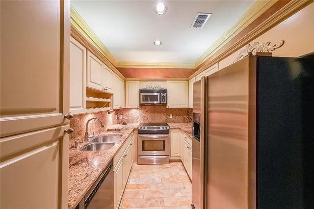 a kitchen with granite countertop cabinets stainless steel appliances and a counter space