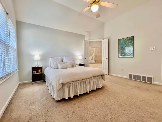 a spacious bedroom with a bed and a chandelier