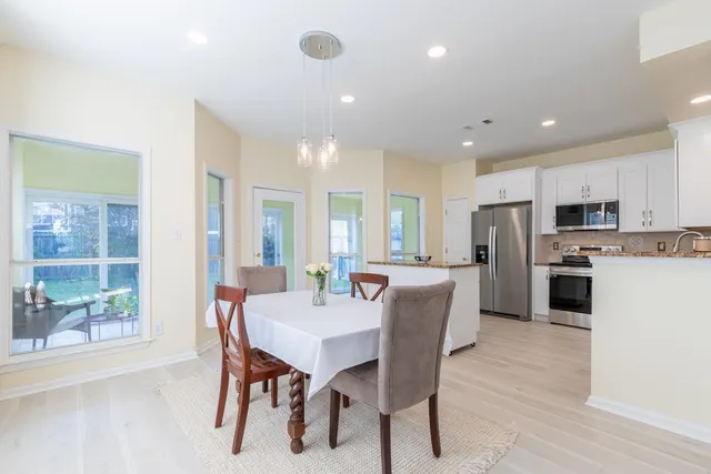 a kitchen with a dining table chairs and refrigerator