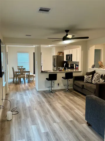 a living room with furniture and a wooden floor