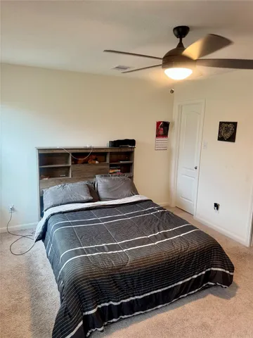 a bedroom with a bed and a ceiling fan