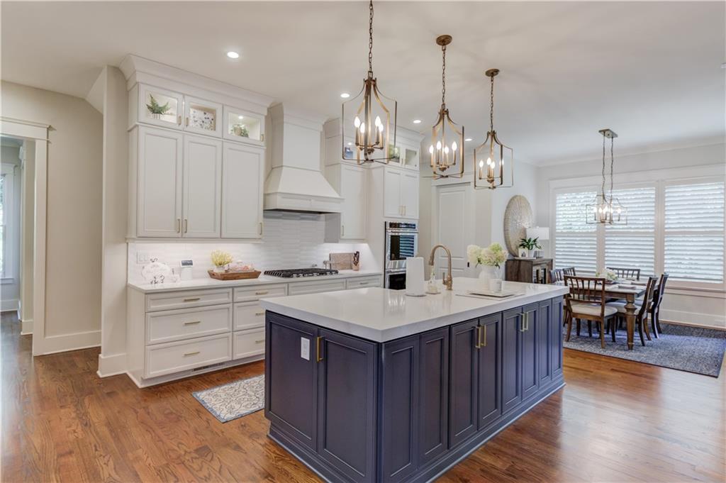 1894 Point River Drive Duluth, GA 30097 - Photo 2 of 17 a large kitchen with kitchen island a island a sink a stove and a wooden floors