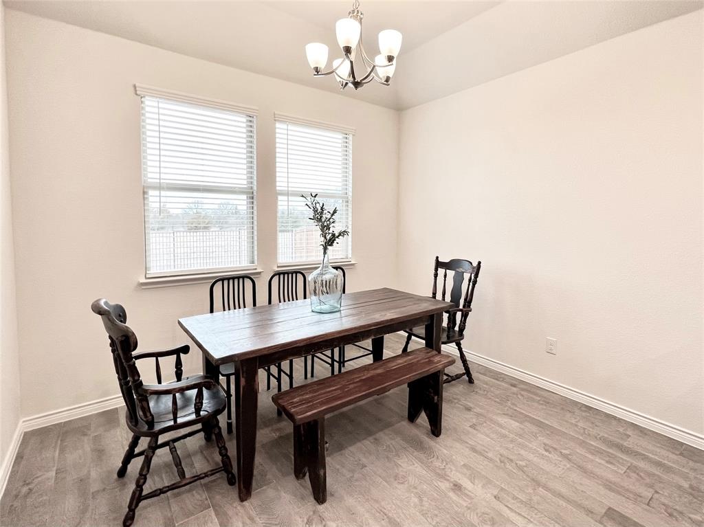 1041 Sublime Drive Forney, TX 75126 - Photo 12 of 26 a dining room with furniture a rug and a chandelier