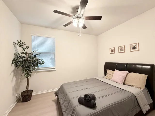 a bedroom with a bed and a potted plant
