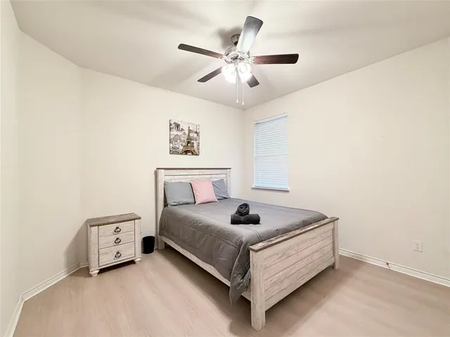 a bedroom with a bed and a ceiling fan