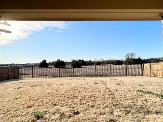 a view of yard with wooden fence