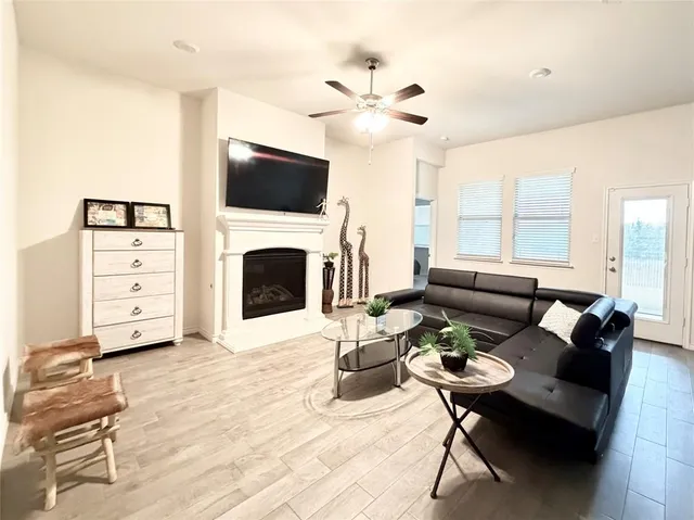 a living room with furniture a fireplace and a flat screen tv