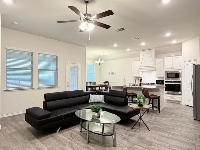 a living room with furniture kitchen view and a window