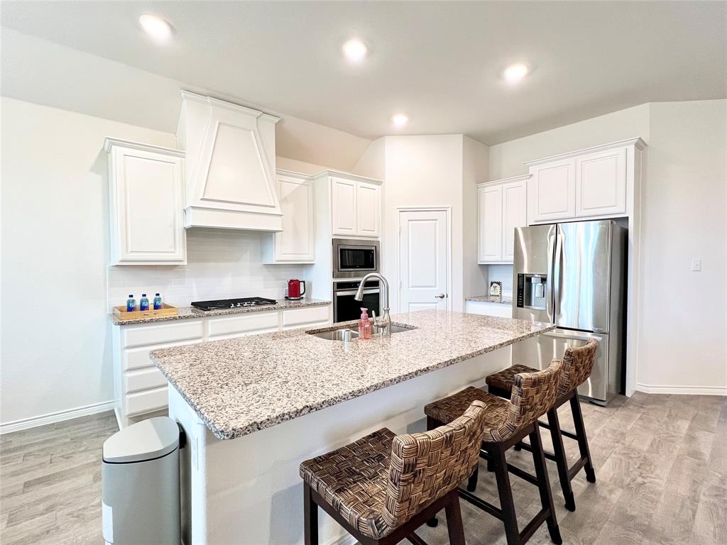 1041 Sublime Drive Forney, TX 75126 - Photo 10 of 26 a kitchen with stainless steel appliances granite countertop a kitchen island hardwood floor and a sink