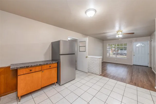 a view of a kitchen with refrigerator and wooden cabinets