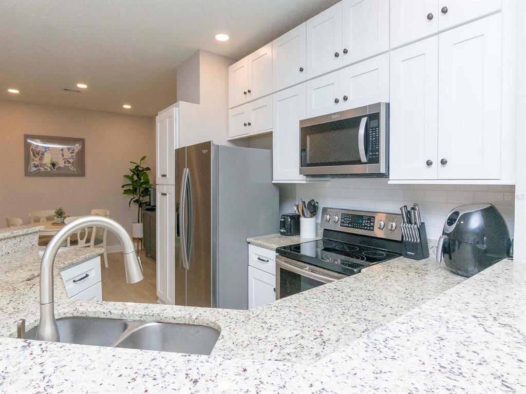1036 Normandy Trace Road Tampa, FL 33602 - Photo 11 of 31 a kitchen with stainless steel appliances kitchen island granite countertop a refrigerator and a sink