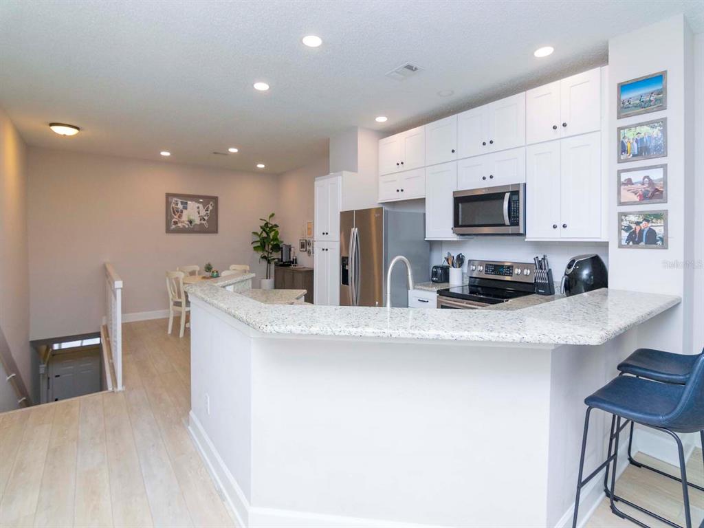 1036 Normandy Trace Road Tampa, FL 33602 - Photo 12 of 31 a kitchen with stainless steel appliances a stove a sink a microwave a refrigerator and cabinets