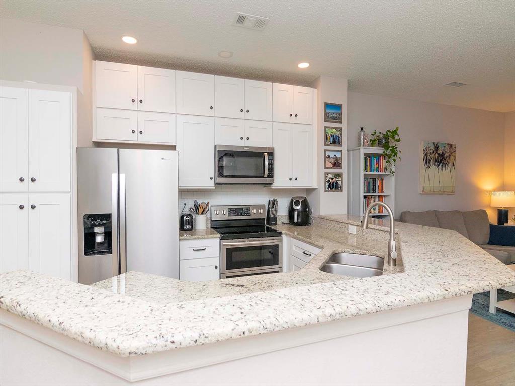 1036 Normandy Trace Road Tampa, FL 33602 - Photo 9 of 31 a kitchen with kitchen island granite countertop a sink stove and refrigerator