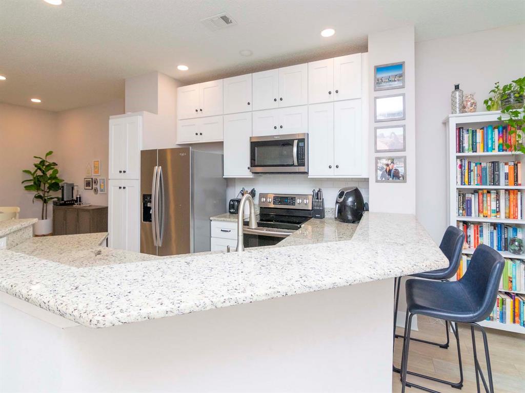 1036 Normandy Trace Road Tampa, FL 33602 - Photo 10 of 31 a kitchen with stainless steel appliances kitchen island granite countertop a refrigerator and a stove top oven with white cabinets