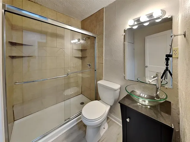 a bathroom with a sink a toilet a mirror a vanity and bathtub