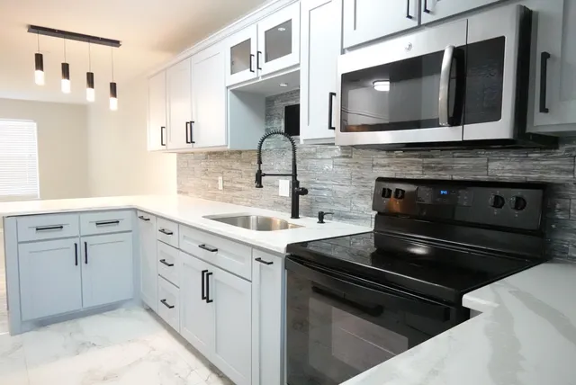 a kitchen with granite countertop cabinets stainless steel appliances and a sink