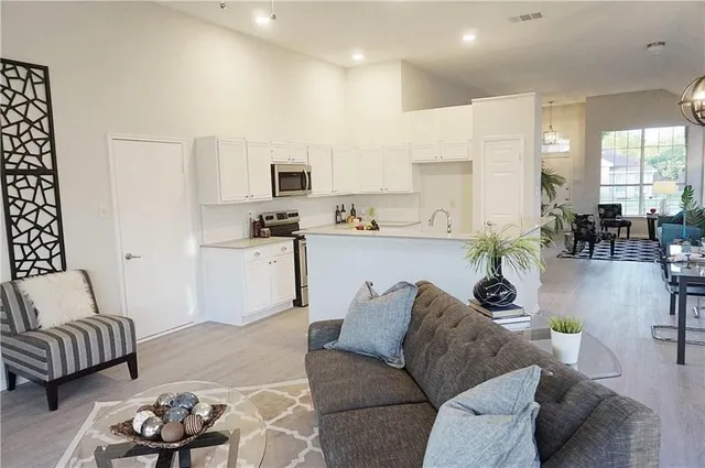 a living room with furniture and kitchen view