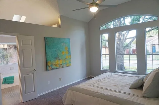 a bedroom with a bed and a large window