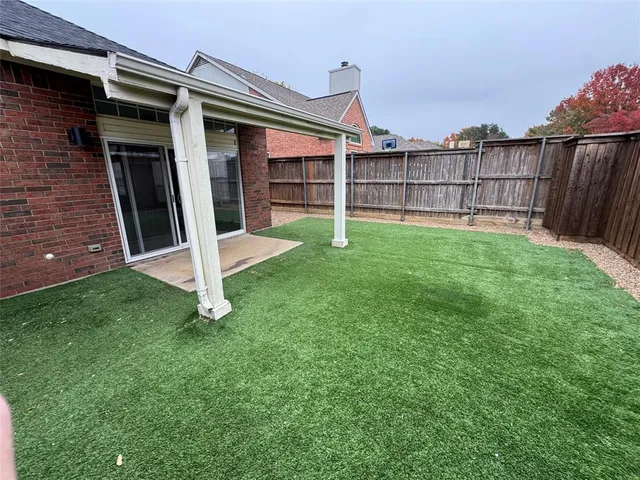 a view of a backyard with a tub and wooden fence