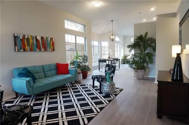 a living room with furniture a dining table and a large window