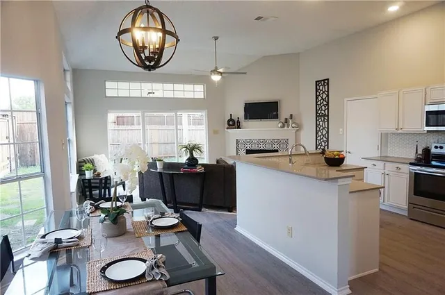 a kitchen with sink refrigerator dining table and chairs