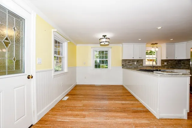 a view of a kitchen with wooden floor and electronic appliances