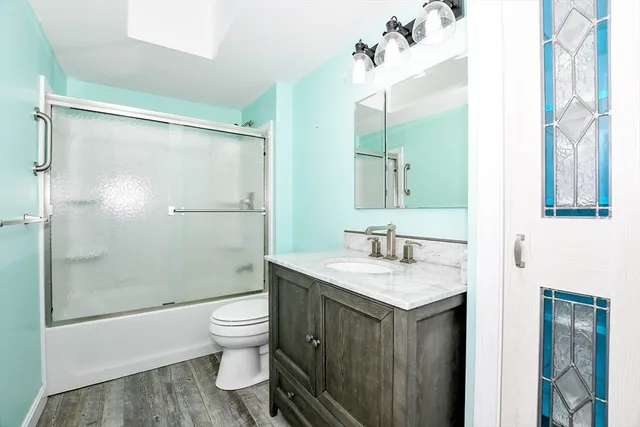 a bathroom with a sink a toilet and shower