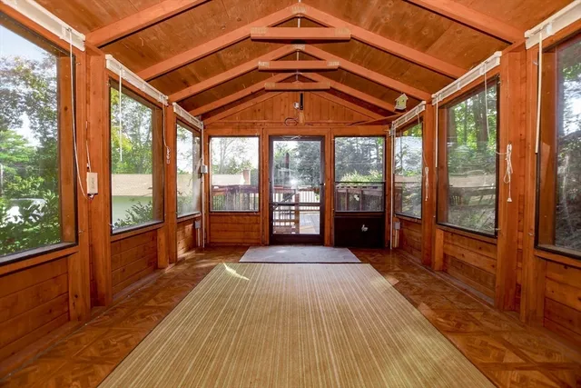 a living room with furniture a flat screen tv and a floor to ceiling window