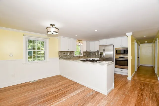 a kitchen with stainless steel appliances granite countertop a refrigerator and a stove top oven