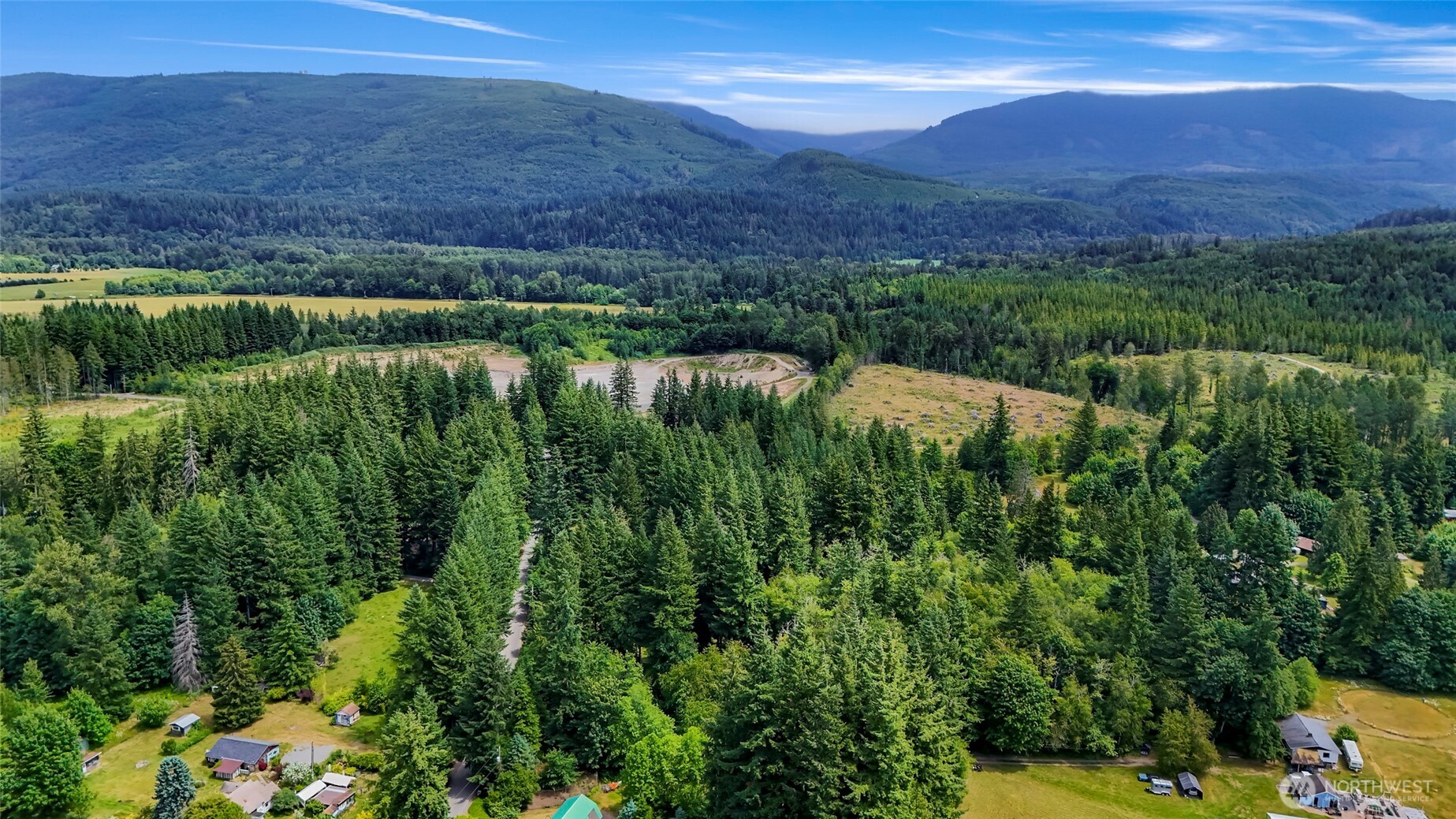 5650 Doran Road Acme, WA 98220 - Photo 12 of 40 a view of a lush green hillside and a building in the background