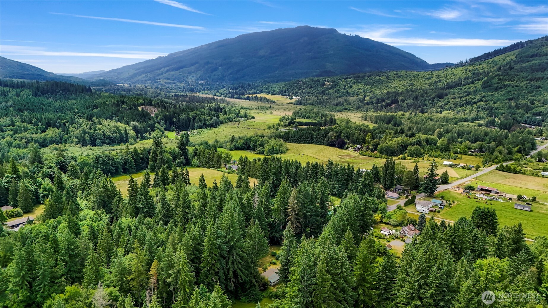 5650 Doran Road Acme, WA 98220 - Photo 5 of 40 a view of a lush green hillside and a building in the background