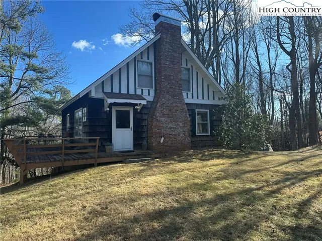 a view of a house with a yard and large tree